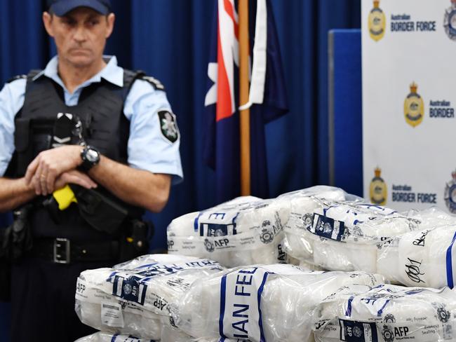 An Australian Federal Police (AFP) officer looks on as bags of crystal methamphetamine are seen on a table before a press conference at the AFP headquarters in Sydney, Thursday, May 10, 2018. Two Taiwanese nationals and a Chinese man are behind bars after more than $100 million worth of the drug ice - disguised as tea - was found hidden inside metal lathes. Australian border officials discovered the drugs in a container that arrived in Sydney from Malaysia on April 21. Each lathe contained packets marked as tea but were filled with 200 kilograms of crystal methamphetamine in what authorities described as a 