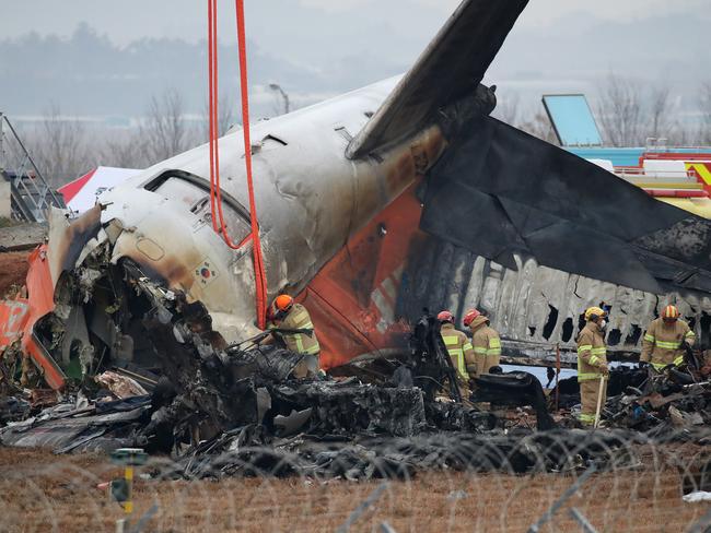 MUAN-GUN, SOUTH KOREA - DECEMBER 30: Firefighters work at the wreckage of a passenger plane at Muan International Airport on December 30, 2024 in Muan-gun, South Korea. A plane carrying 181 people, Jeju Air Flight 7C2216, crashed at Muan International Airport in South Korea after skidding off the runway and colliding with a wall, resulting in an explosion. Early reports said that at least 179 people had died. (Photo by Chung Sung-Jun/Getty Images) *** BESTPIX ***