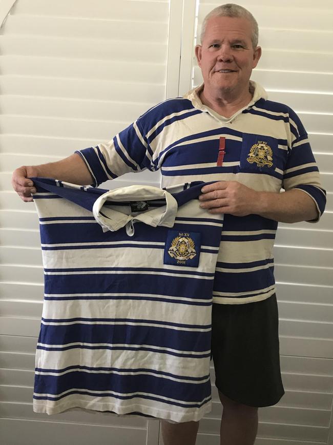 Tony D'Arcy earing his Nudgee College jersey and holding the Firsts jumper of his late son, Christopher.