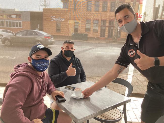 Anthony and Vince Calvi prepare for breakfast and a coffee at Kaffenio in Mildura, served by manager Chris Kimerlis.