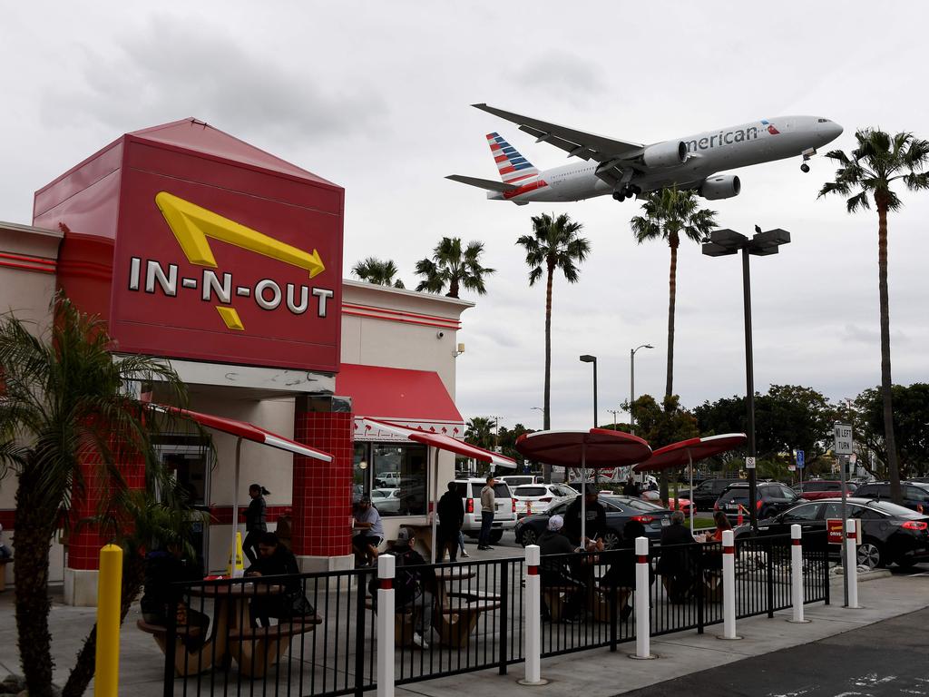 An American Airlines plane flies over a fast food restaurant as it prepares to land at Los Angeles International Airport in Los Angeles, California. Picture: AFP