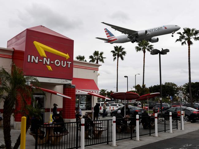 An American Airlines plane flies over a fast food restaurant as it prepares to land at Los Angeles International Airport in Los Angeles, California. Picture: AFP