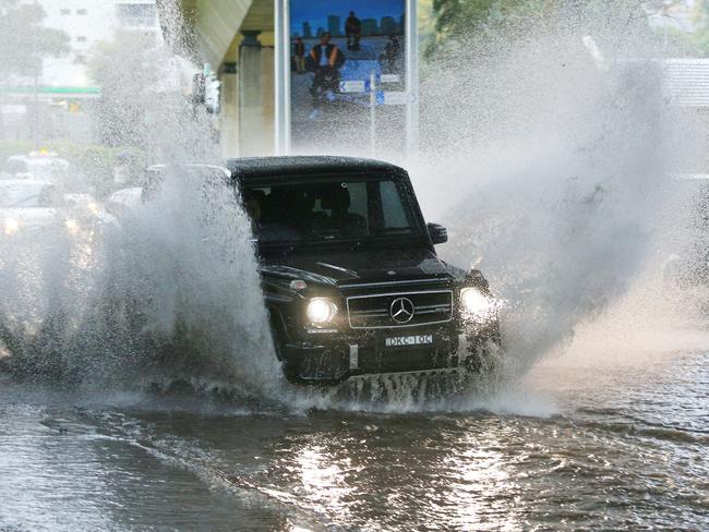 Cars drive through floods at New South Head Road, Rushcutters Bay, during a heavy downpour of rain this week. Picture: Mark Evans