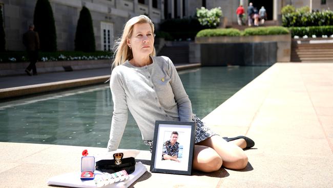 Julie Anne Finney holds an image of her son David with his medals and hat at the Pool of Reflection in the commemorative courtyard at the Australian War Memorial in Canberra. Picture: Tracey Nearmy/Advertiser