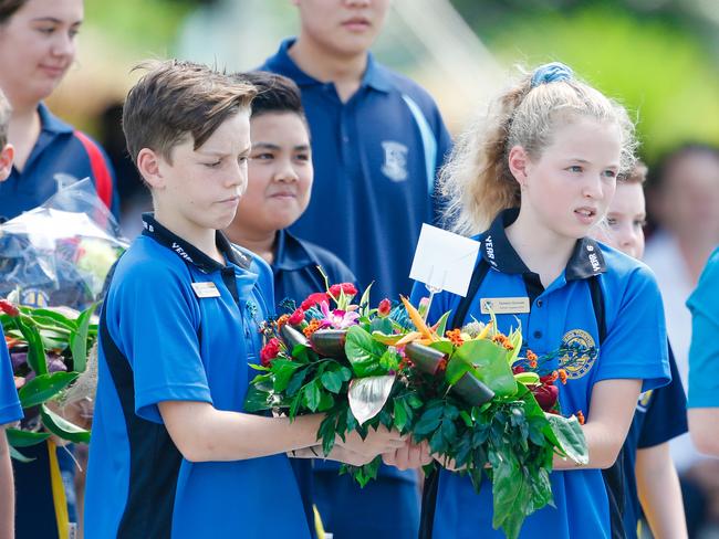 Parap Primary School captains Zach Broadbent and Tamsin Groves carry a wreath to the cenotaph during the 77th Anniversary of the Bombing of Darwin special commemorative service in Darwin, Tuesday, February 19, 2019. (AAP Image/GLENN CAMPBELL)