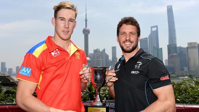 Tom Lynch and Travis Boak with a trophy Gold Coast and Port Adelaide will play for in China.