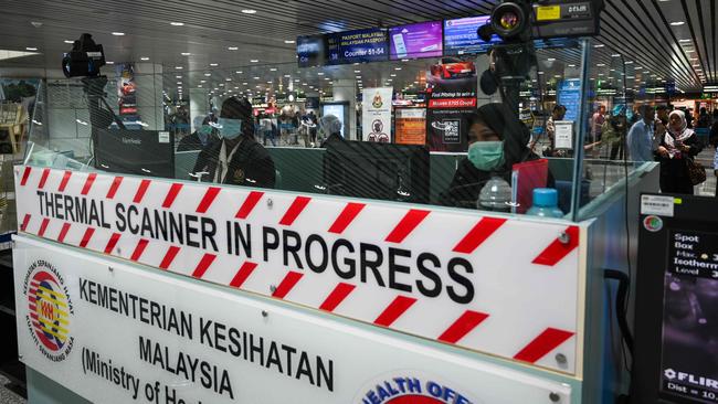 Health officers screen arriving passengers with thermal scanners at Kuala Lumpur International Airport on Tuesday. Picture: AFP