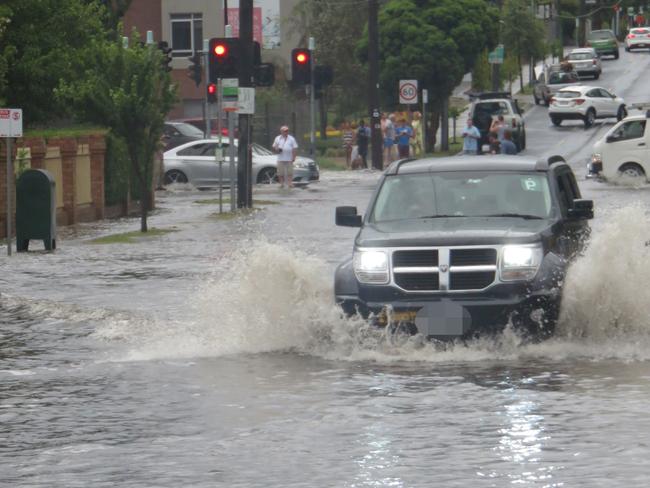 A car tries to make its way through flooding in Hawthorn Rd, Brighton East. Picture: Peter Farrar