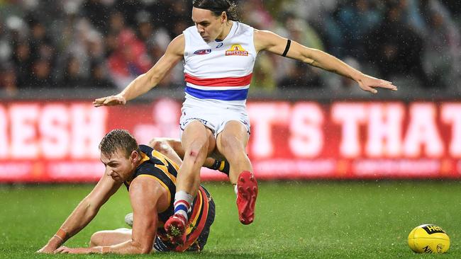 Daniel Talia slides across the wet turf in Adelaide, tripping Bulldog Lukas Webb.