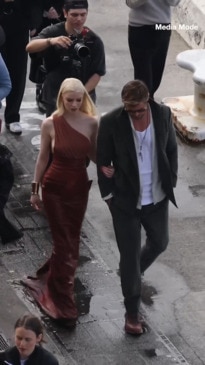 Chris Hemsworth leads Anya Taylor-Joy through puddles, soaking her dress