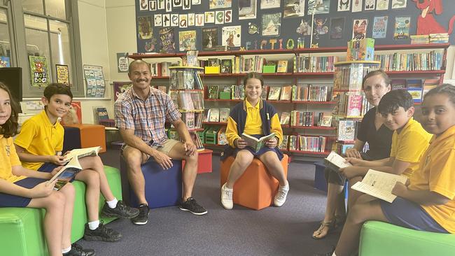 Lake Heights Primary School teacher Johnny Finkernagel, left, with primary interventionist Maria Batist, as well as a number of students who sat the 2021 NAPLAN