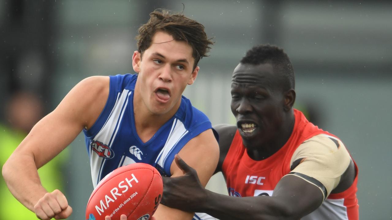 Curtis Taylor handballs under pressure from Aliir Aliir during Monday’s Marsh Series game.