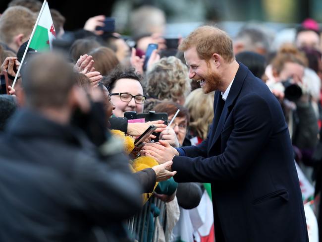 Prince Harry and his fiancee Meghan Markle sign autographs as they arrive to a walkabout at Cardiff Castle on January 18, 2018 in Cardiff, Wales. Picture: Getty