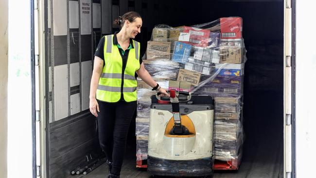 Woolworths has taken delivery of 448 pallets of groceries for their Far North Queensland stores, after flooding rains cut the road network and stopped deliveries. Woolworths Cairns Central assistant store manager Lauren Oxenham removes pallets of food off the truck on Thursday morning. Picture: Brendan Radke