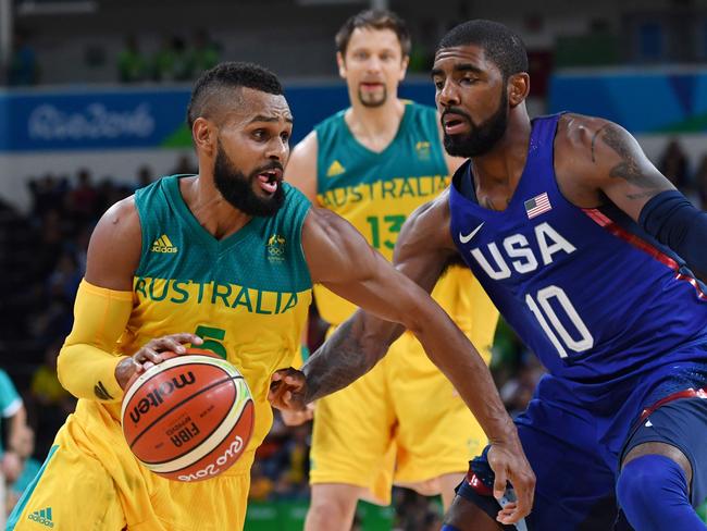 Australia's guard Patty Mills (L) tries to pass USA's guard Kyrie Irving during a Men's round Group A basketball match between Australia and USA at the Carioca Arena 1 in Rio de Janeiro on August 10, 2016 during the Rio 2016 Olympic Games. / AFP PHOTO / Andrej ISAKOVIC