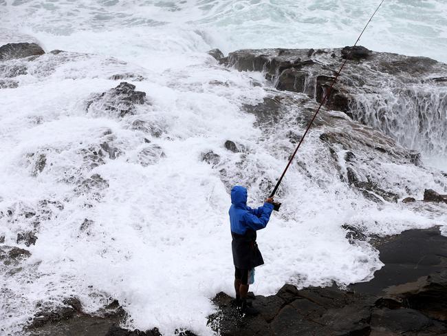 Is A Fish Really Worth It ? Big seas, driving rain and no life jacket is a recipe for rock fishing disaster at Newcastle's dangerous Bogey Hole. Picture: Peter Lorimer