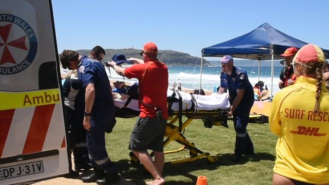 Ambulance officers take the rescued man from Palm Beach to hospital. Picture: TNV