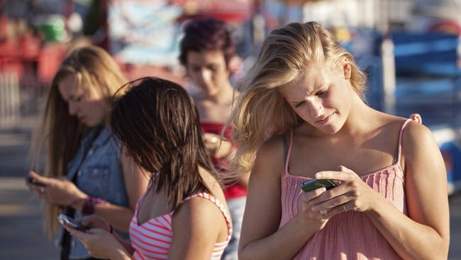 Teenagers using smart phones. Thinkstock