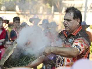 Gene Blow performs an indigenous smoking ceremony to keep students safe as part of Harmony Day celebrations at Rangeville State School. Picture: Kevin Farmer