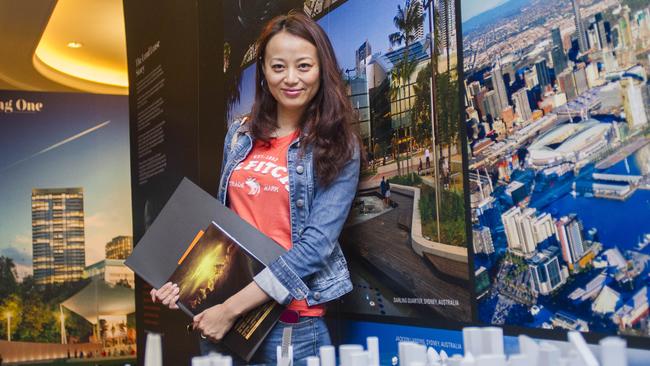 June 21, 2014, Shanghai, China -Amy Chen, 30, stands a model of central Sydney at a Sydney property showcase by Lend Lease at the Four Seasons Hotel. Chen works at an estate agent that specialises in properties in Australia, Malaysia, Singapore and Dubai. She says she plans to move to Australia because of the lack of pollution and what she feels is a more comfortable and easier lifestyle than in China.