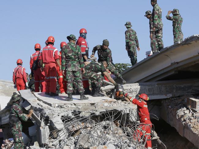 Rescuer teams working to locate victims trapped beneath rubble. Picture: AP Photo/Tatan Syuflana
