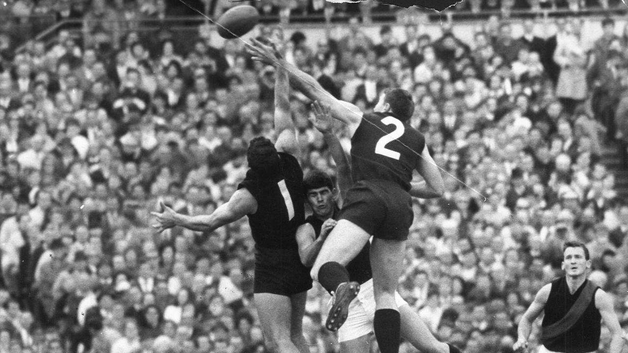 John Nicholls and Sergio Silvagni sandwich an Essendon player as they fly for the ball in 1968.