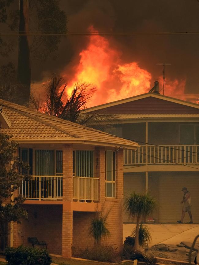 Fires burn behind houses in Malua Bay NSW. New Picture: Alex Coppel.