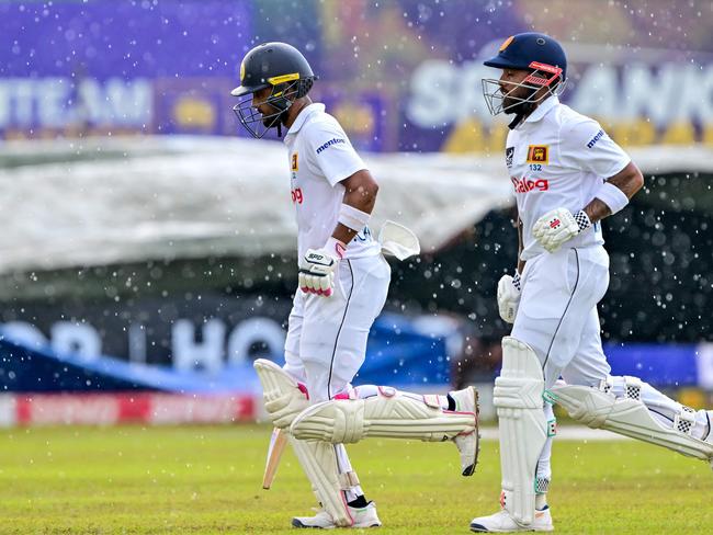 Sri Lanka's Dinesh Chandimal and Kusal Mendis walk off the field after rain halts play. Picture: AFP