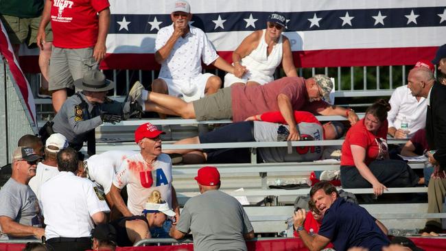 Donald Trump supporters are seen covered with blood in the stands after gun shots were fired. Picture: AFP