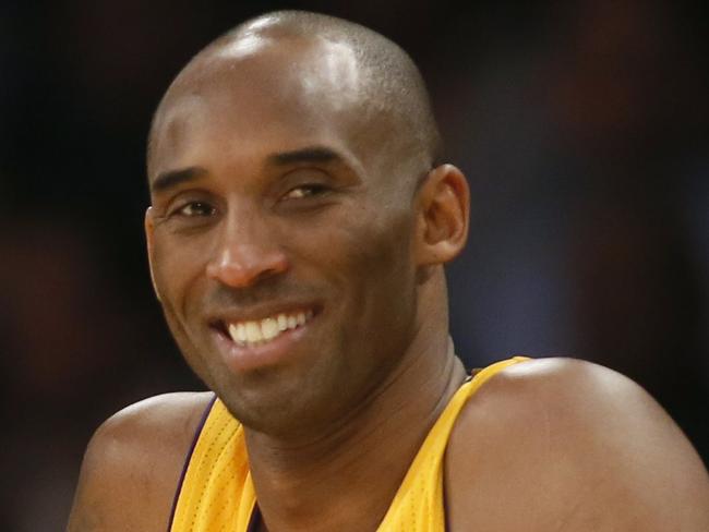 Los Angeles Lakers coach Byron Scott, left, and Kobe Bryant, right, smile on the sideline as Bryant waits for a stop in play to enter the NBA basketball game against the Milwaukee Bucks during the first half Tuesday, Dec. 15, 2015, in Los Angeles. (AP Photo/Danny Moloshok)