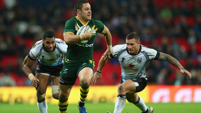 Jarryd Hayne (centre) bursts past Sisa Ledua Waqa (left) and Tariq Sims (right) of Fiji on his way to scoring a try during the Rugby League World Cup Semi Final match between Australia and Fiji at Wembley Stadium in 2013 in London, England. Photo: Michael Steele/Getty Images