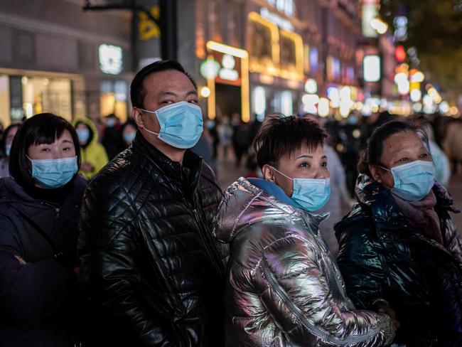 People stand around a giant 3D screen in Wuhan on the first anniversary of China confirming its first death from COVID. Picture: AFP