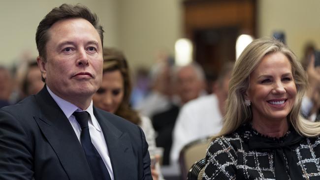 Elon Musk, left, sits with Kelly Johnson, wife of House Speaker Mike Johnson as President-elect Donald Trump speaks at a meeting of the House GOP conference earlier today. Picture: AFP.