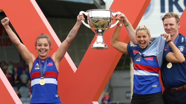 Ellie Blackburn (left), Katie Brennan (who missed the match through suspension) and coach Paul Groves celebrate with the trophy. (AAP Image/Hamish Blair)