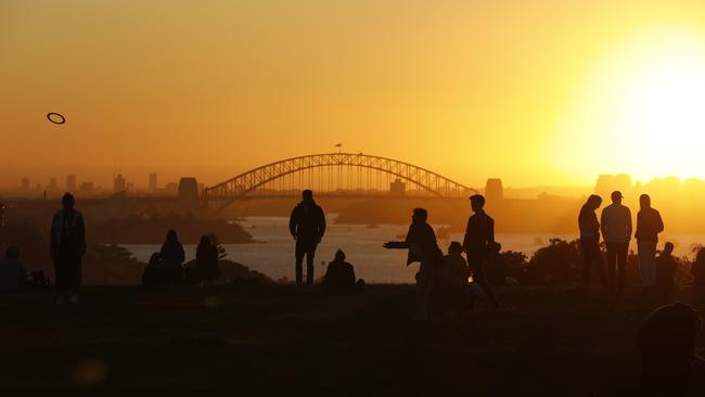 People enjoy the sun set from Dudley Page Reserve in Dover Heights with the Sydney Harbour Bridge pictured in the background. 1st August 2020. Picture by Damian Shaw