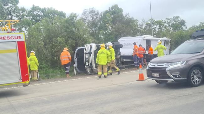 Emergency crews attend a single-vehicle rollover on the Pacific Mwy at Yatala. Picture: John Paterson