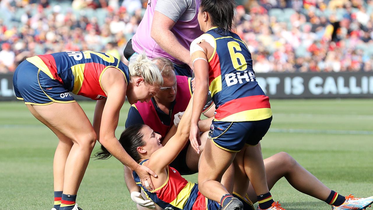 Angela Foley is helped by teammates after injuring her knee.