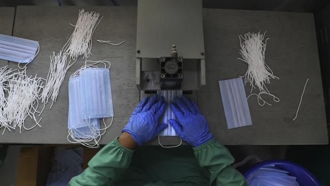 A Central Reserve Police Force soldier stitches face masks for health workers combating the spread of the new coronavirus in New Delhi, India.