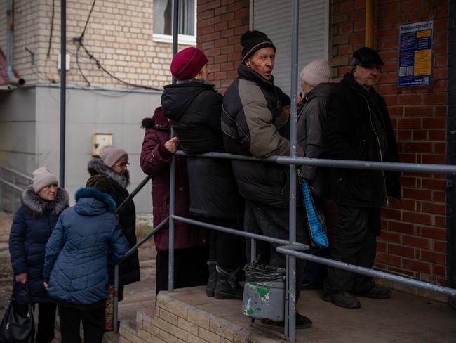 People queue outside a bank that closed during an air raid alert in Izyum, Ukraine. Picture: Getty Images