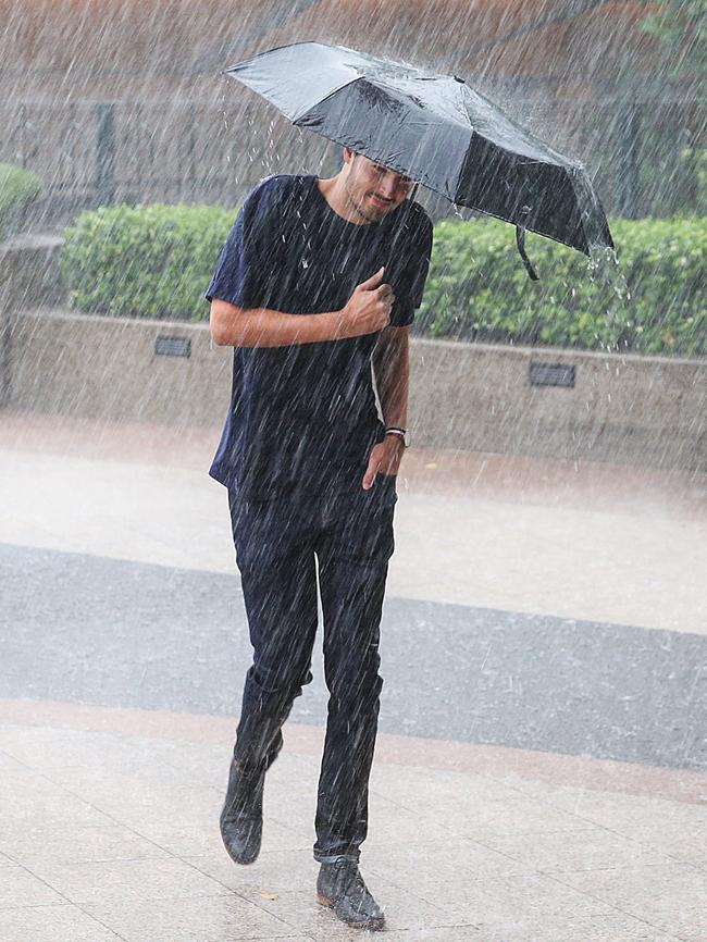 A man uses his umbrella to shield himself the rain. Picture: Ian Currie