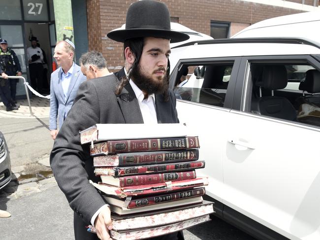 Church members remove religious material from Addass Israel synagogue at Ripponlea after an overnight fire. Picture: Andrew Henshaw