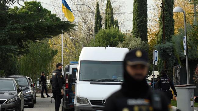 Spanish policemen stand next to an Ukrainian flag while securing the area after a letter bomb explosion at the Ukraine's embassy in Madrid. Picture: AFP