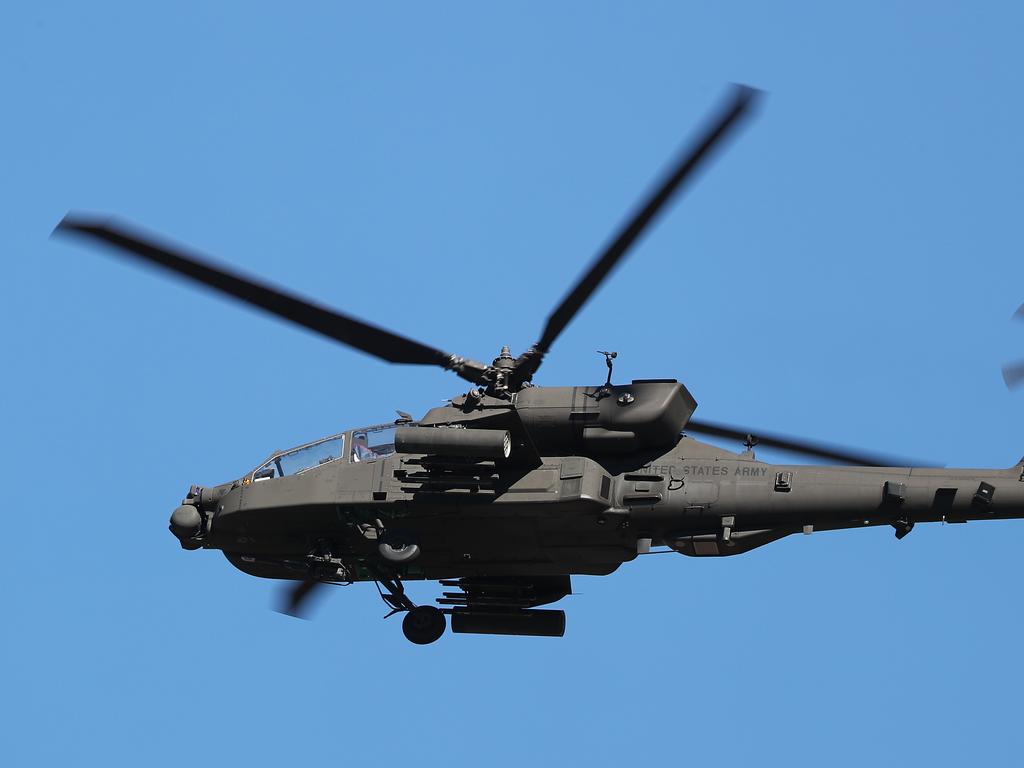 An American Apache flies over Rockhampton. Australian and American troops on the ground at Camp Rockhampton. Pic Peter Wallis