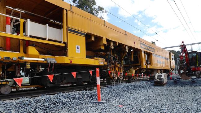 A tamper machines adjusts and packs stones ballast under the tracks for the Cross River Rail project