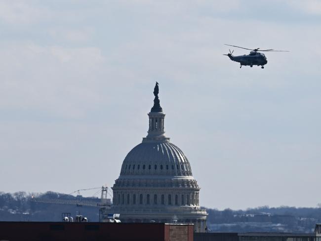 A helicopter carrying former US President Joe Biden and former First Lady Jill Biden flies by the US Capitol following the inauguration of US President Donald Trump, in Washington, DC, on January 20, 2025. (Photo by Patrick T. Fallon / AFP)