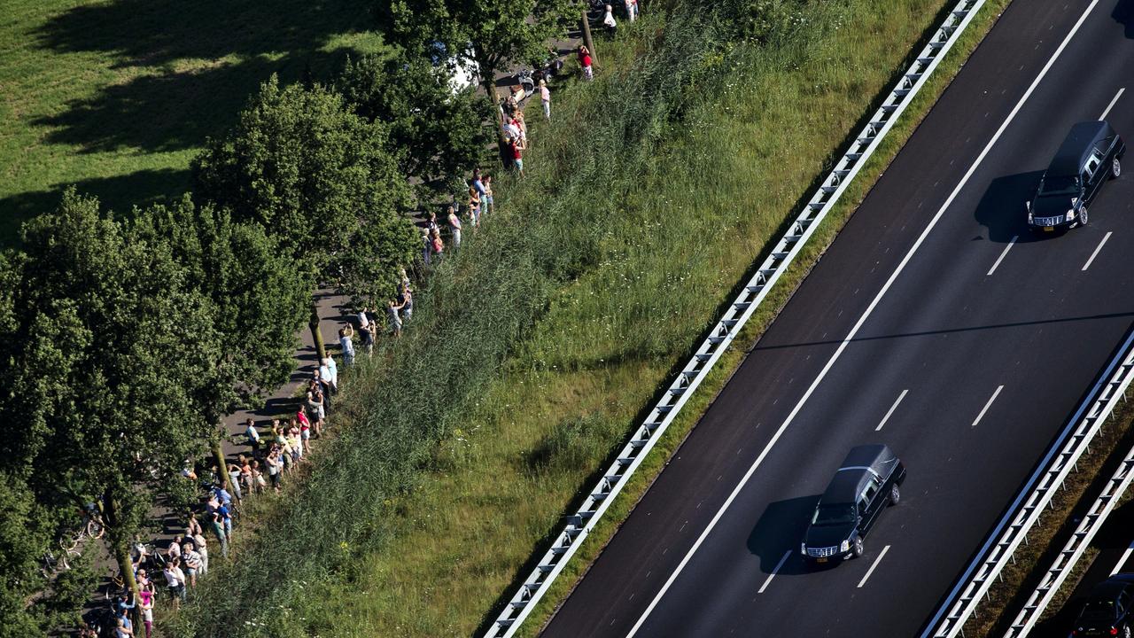 An aerial view taken on July 23, 2014 shows people standing on the side of the road as the convoy of hearses carrying the bodies of victims is on its way to Hilversum. Picture: Jerry Lampen / ANP / AFP