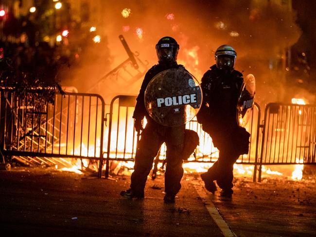 Police stand by burning barricades in front of the White House during a protest against the death of George Floyd. Picture: AFP