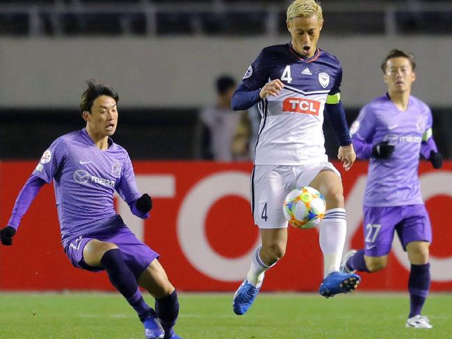 Kohei Shimizu (R) of Japan's Sanfrecce Hiroshima and Keisuke Honda (C) of Australia's Melbourne Victory fight for the ball during their AFC Champions League group stage football match in Hiroshima on March 12, 2019. (Photo by JIJI PRESS / JIJI PRESS / AFP) / Japan OUT