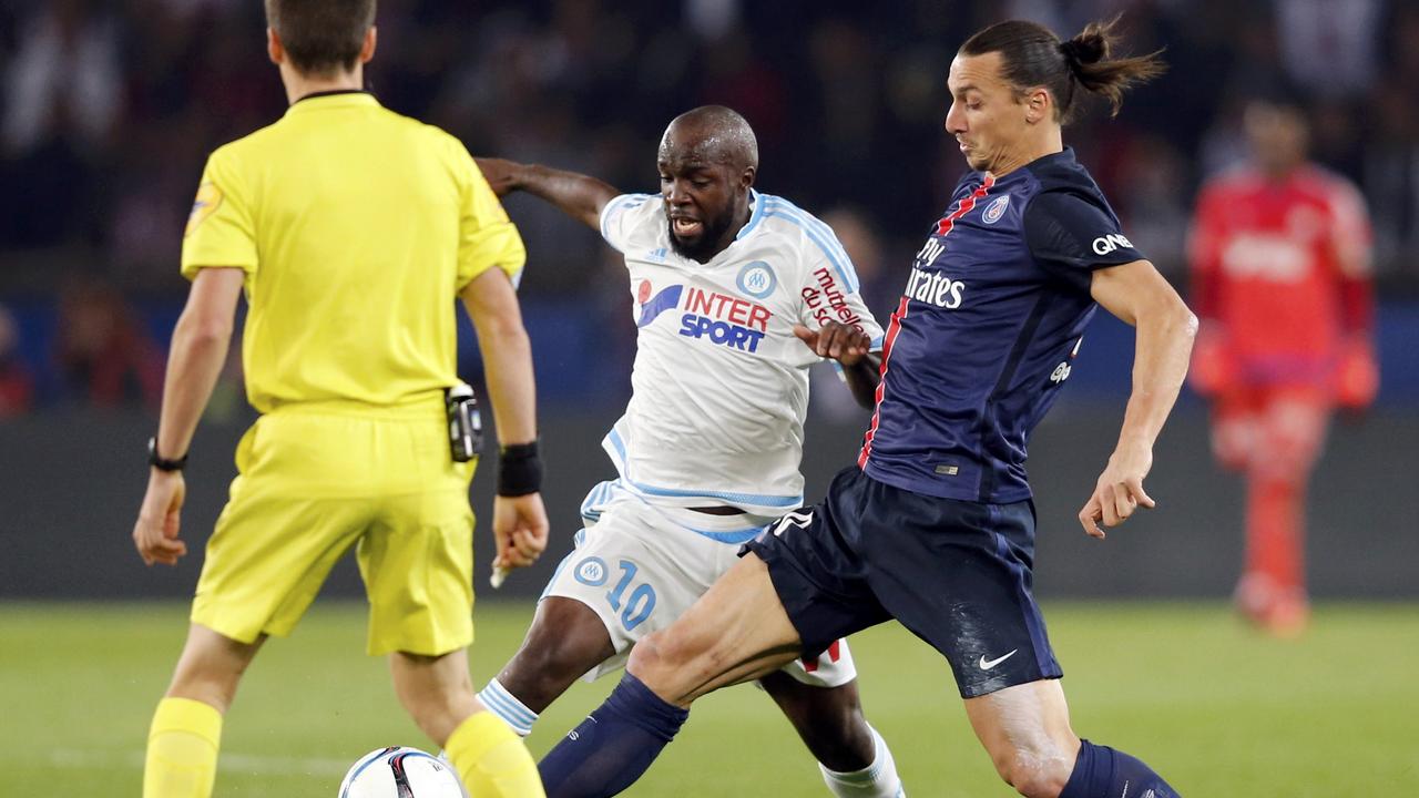 Paris St Germain's Zlatan Ibrahimovic (R) challenges Olympique Marseille's Lassana Diarra (C) as referee Benoit Bastien (L) looks on during their French Ligue 1 soccer match at the Parc des Princes stadium in Paris, France, October 4, 2015. REUTERS/Regis Duvignau