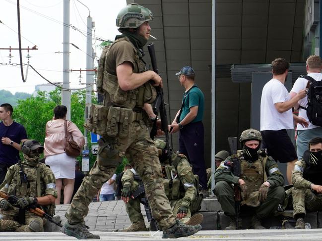 Members of Wagner group sit on the sidewalk as they patrol the centre of Rostov-on-Don, on June 24. Picture: AFP